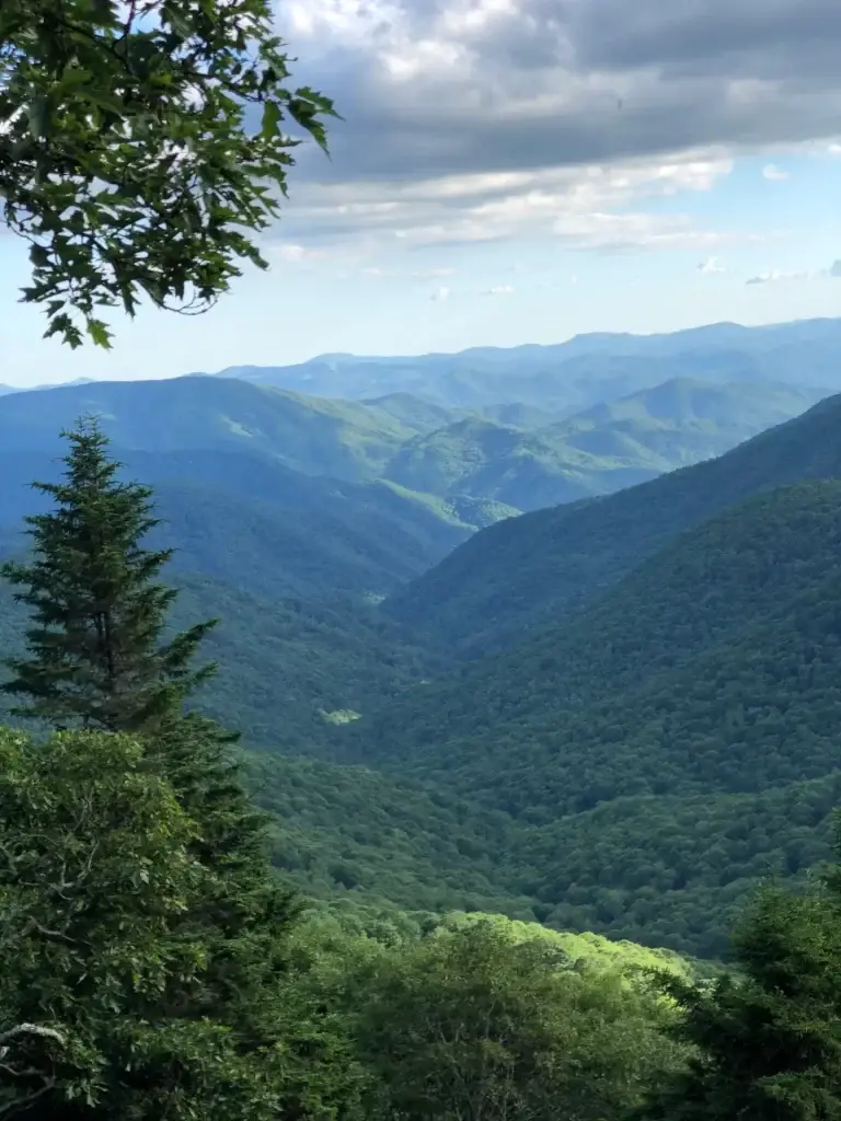 Expansive mountain valley with rolling hills and lush greenery, reflecting the journey to recovery at FIRST at Blue Ridge.